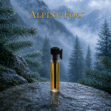 Alpine Fog™ perfume and cologne concentrate in an amber glass bottle with a blue-and-gold label, displayed against misty alpine mountains and wet silver fir branches - 1ml sample