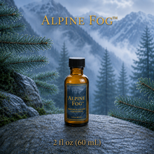 Alpine Fog™ perfume and cologne concentrate in an amber glass bottle with a blue-and-gold label, displayed against misty alpine mountains and wet silver fir branches - 2oz