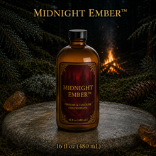 Midnight Ember™ perfume and cologne concentrate in an amber glass bottle with burgundy label beside a campfire in a dark evergreen forest -  16 fl oz 