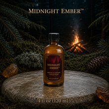 Midnight Ember™ perfume and cologne concentrate in an amber glass bottle with burgundy label beside a campfire in a dark evergreen forest -  4 fl oz