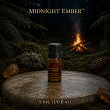 Midnight Ember™ perfume and cologne concentrate in an amber glass bottle with burgundy label beside a campfire in a dark evergreen forest -  5ml 