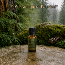 PNW Rainforest Fougère perfume concentrate sample vial with yellow liquid on a pale rock in a wet Pacific Northwest evergreen forest - 10ml glass bottle