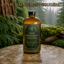 PNW Rainforest Fougère perfume concentrate sample vial with yellow liquid on a pale rock in a wet Pacific Northwest evergreen forest - 16oz glass bottle