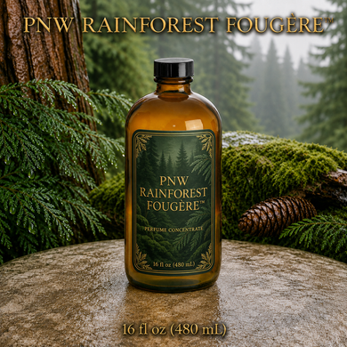 PNW Rainforest Fougère perfume concentrate sample vial with yellow liquid on a pale rock in a wet Pacific Northwest evergreen forest - 16oz glass bottle