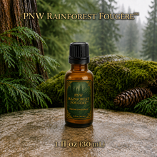 PNW Rainforest Fougère perfume concentrate sample vial with yellow liquid on a pale rock in a wet Pacific Northwest evergreen forest - 1oz glass bottle