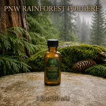 PNW Rainforest Fougère perfume concentrate sample vial with yellow liquid on a pale rock in a wet Pacific Northwest evergreen forest - 2oz glass bottle