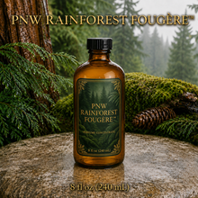 PNW Rainforest Fougère perfume concentrate sample vial with yellow liquid on a pale rock in a wet Pacific Northwest evergreen forest - 8oz glass bottle